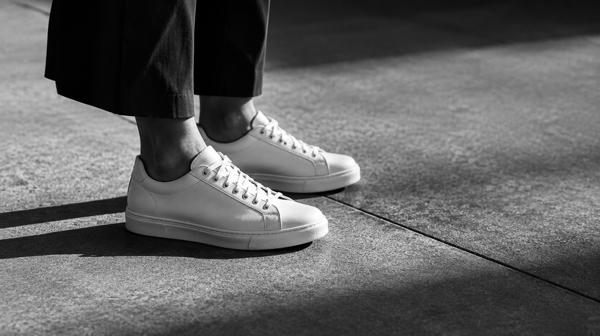Gros plan noir et blanc de sneakers sur un trottoir urbain - UnifitPro