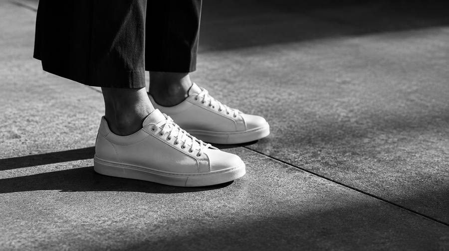 Gros plan noir et blanc de sneakers sur un trottoir urbain - UnifitPro